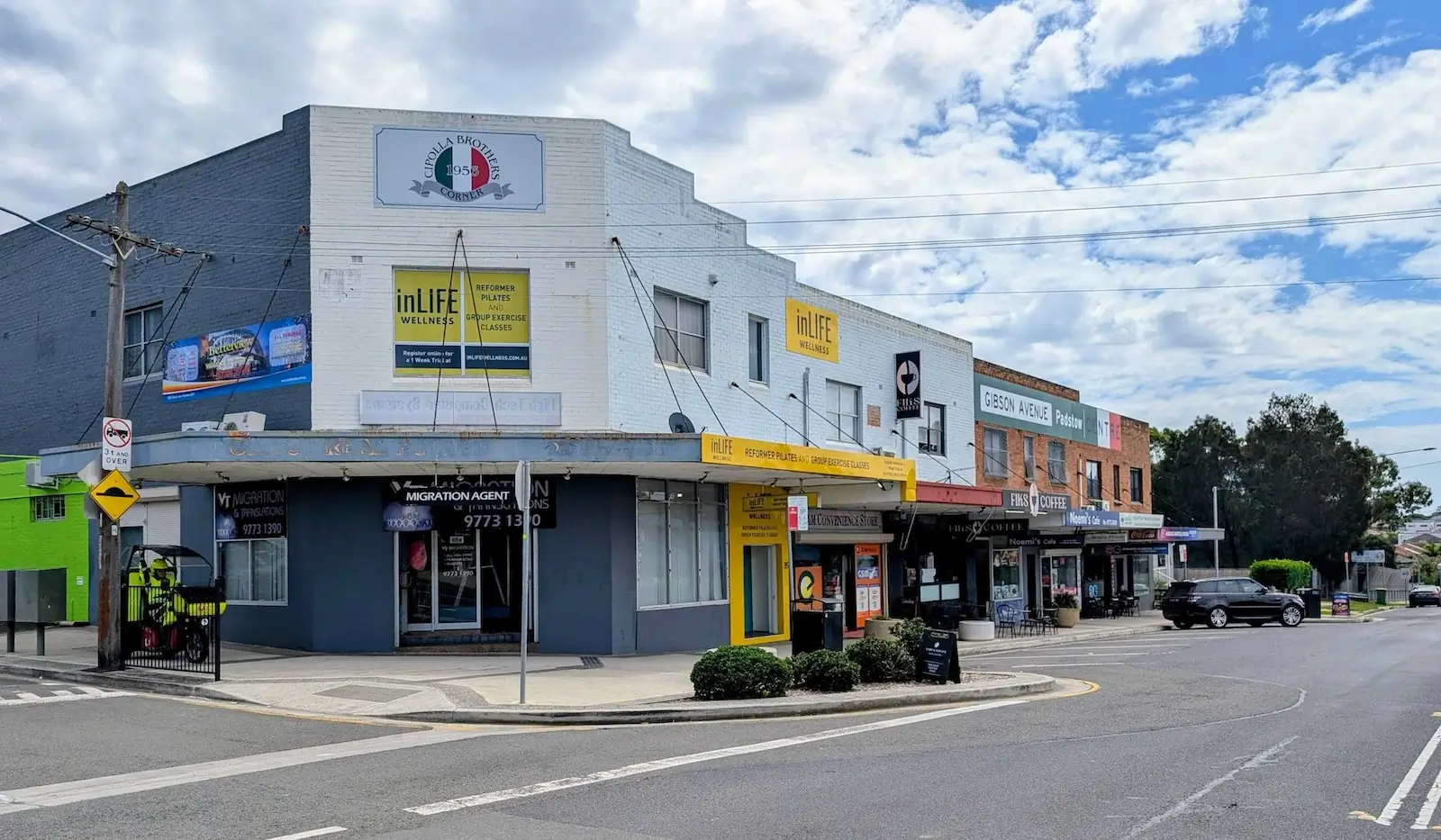 Street view of Gibson Avenue commercial precinct in Padstow, featuring local businesses, shops, cafes, and wellness services.