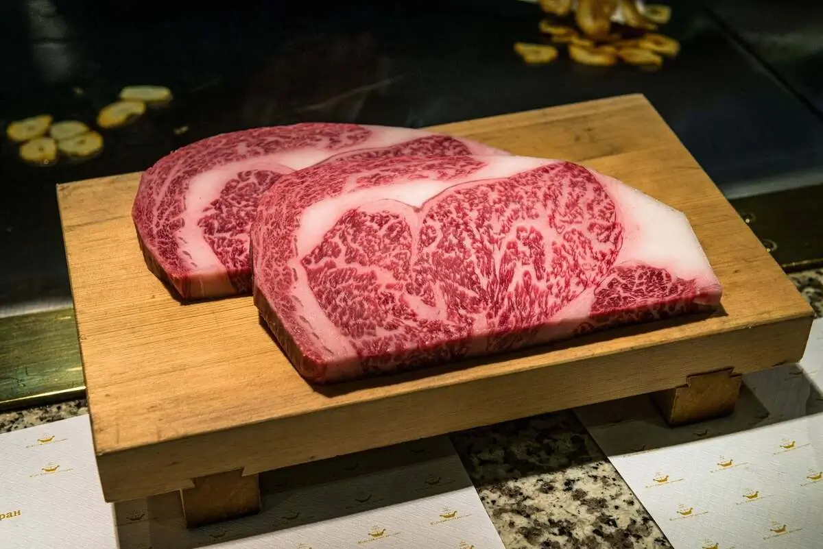 Japanese A5 Wagyu steaks with rich marbling on a wooden serving board